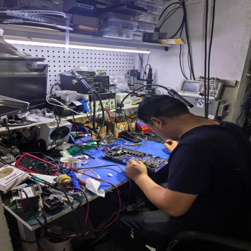 The engineer is repairing a circuit board (variable-frequency drive board for refrigeration compressors